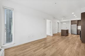 Portland apartment for rent - A spacious living room with wooden flooring and white walls.