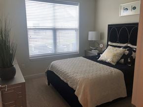Dickinson apartment for rent - A bedroom with a bed, nightstand, and window with blinds.