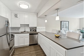 Portland apartment for rent - Kitchen with overhead lighting, white cabinets, and stainless steel appliances at  735 St. Clair Apartments in Portland, Oregon