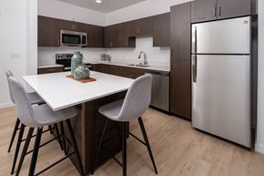Layton apartment for rent - A modern kitchen with a white table and grey chairs.