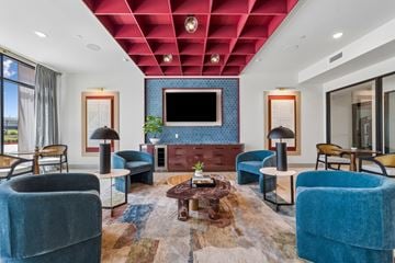 Garland apartment for rent - A living room with a blue couch and a television.