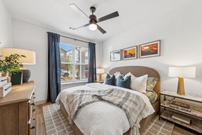 Melissa apartment for rent - A bedroom with a bed, a ceiling fan, and a window with curtains.