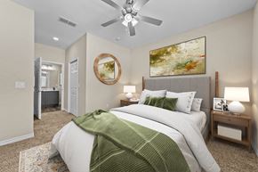 Longview apartment for rent - A bedroom with a large bed and a ceiling fan.