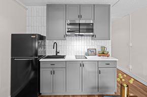 Yakima apartment for rent - a kitchen with white cabinets and a black refrigerator