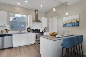 Tucson apartment for rent - A modern kitchen with white cabinets and a large island.