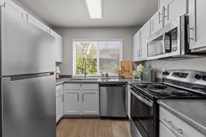 Kennewick apartment for rent - a kitchen with stainless steel appliances and white cabinets