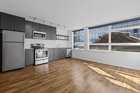 Seattle apartment for rent - an empty kitchen with stainless steel appliances and a large window