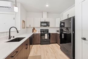 Pasco apartment for rent - A modern kitchen with a black refrigerator and wooden floors.