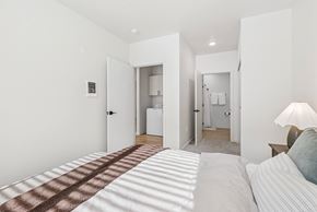 Pasco apartment for rent - A bedroom with a bed in the foreground and a bathroom visible through a doorway.