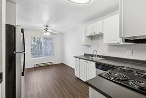 Lynwood apartment for rent - A kitchen with a black stove top oven and white cabinets.