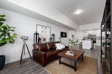 Bluffdale apartment for rent - A living room with a brown leather couch and a wooden coffee table.