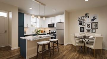 Killeen apartment for rent - A kitchen with a table and chairs in front of a refrigerator.