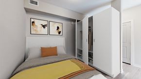Denver apartment for rent - A bedroom with a bed, a yellow blanket, and two pictures on the wall.
