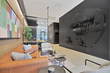 Portland apartment for rent - A living room with a brown couch and a large black and white dinosaur print on the wall.