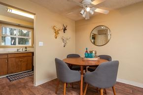 Eugene apartment for rent - A dining room with a round mirror, a wooden table, and grey chairs.