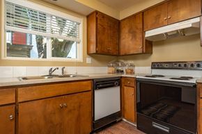 Eugene apartment for rent - A kitchen with wooden cabinets and a stove top oven.