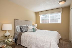 Eugene apartment for rent - A bedroom with a bed, nightstand, and window.