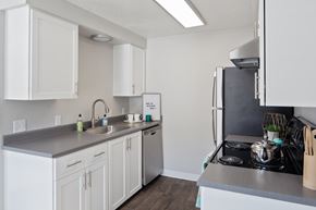 Gresham apartment for rent - A kitchen with white cabinets and a stainless steel counter.