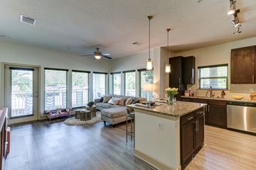 Celebration apartment for rent - A kitchen with a large island and a dining area with a table and chairs.