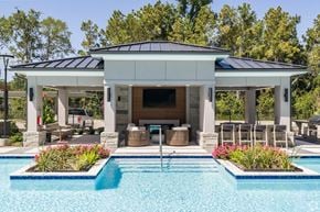 Spring apartment for rent - A pool house with a black roof and white columns.