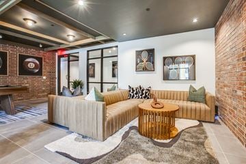 Plano apartment for rent - A living room with a tan couch and a wooden coffee table.