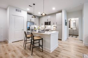 Plano apartment for rent - A kitchen with a white counter and a chair.