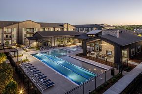 Colorado Springs apartment for rent - an aerial view of a swimming pool at night with apartments in the background