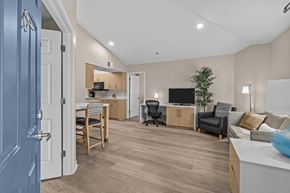 Sandy Springs apartment for rent - A living room with a blue door and a grey couch.