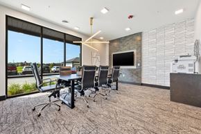 O Fallon apartment for rent - A conference room with a stone wall and a television.
