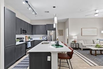 Phoenix apartment for rent - A modern kitchen with dark wood cabinets and a white island.