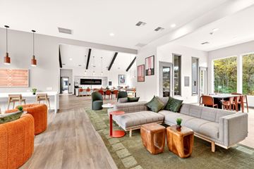 Bremerton apartment for rent - A modern living room with a grey sofa and orange ottoman.