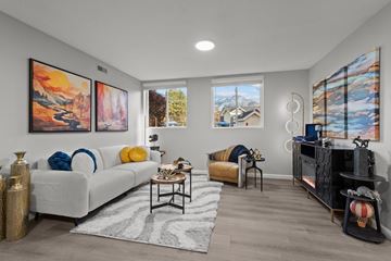 Salt Lake City apartment for rent - A living room with a white couch, a coffee table, and two paintings on the wall.