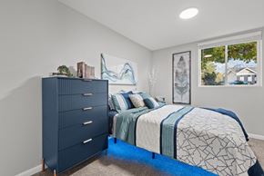 Salt Lake City apartment for rent - A bedroom with a dark blue dresser and a bed with a blue and white comforter.
