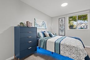 Salt Lake City apartment for rent - A bedroom with a dark blue dresser and a bed with a blue and white comforter.