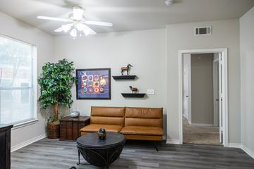 San Antonio apartment for rent - A living room with a brown couch and a ceiling fan.