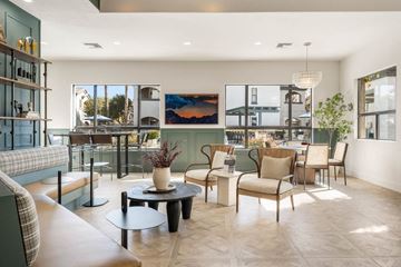 Phoenix apartment for rent - A living room with a large painting on the wall and a view of the outside.