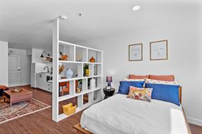 Kennewick apartment for rent - a bedroom with white walls and a white bed with blue and orange pillows