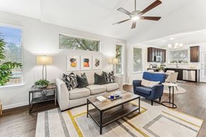 Austin apartment for rent - A living room with a white ceiling fan and a blue chair.