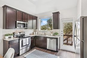 Austin apartment for rent - A kitchen with dark brown cabinets and stainless steel appliances.