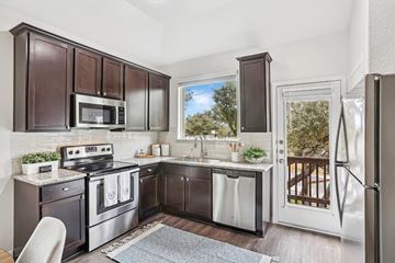 Austin apartment for rent - A kitchen with dark brown cabinets and stainless steel appliances.
