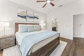 Austin apartment for rent - A bedroom with a bed, nightstand, and a painting on the wall.