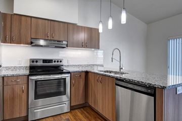 Bend apartment for rent - A modern kitchen with wooden cabinets and stainless steel appliances.