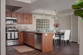 West Jordan townhouse for rent - A kitchen with a wooden island and white chairs.