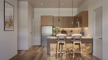 Bend apartment for rent - A kitchen with a refrigerator, a sink, and a counter with chairs.