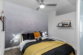 Bothell apartment for rent - A bedroom with a bed, a ceiling fan, and a small table with a lamp.