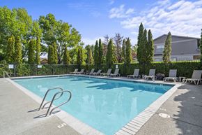 Medford apartment for rent - a swimming pool with lounge chairs and trees in the background