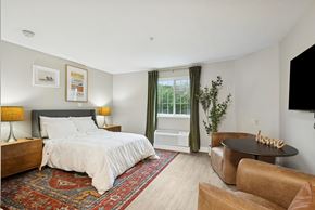 Houston apartment for rent - A bedroom with a large bed and a brown leather chair.