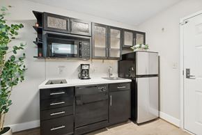 Houston apartment for rent - A kitchen with black cabinets and appliances, a white counter, and a door on the right.