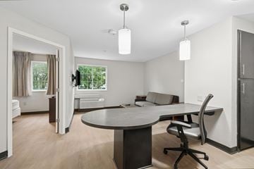 Houston apartment for rent - A modern living room with a round table and a television.