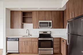 Portland apartment for rent - a kitchen with stainless steel appliances and wooden cabinets